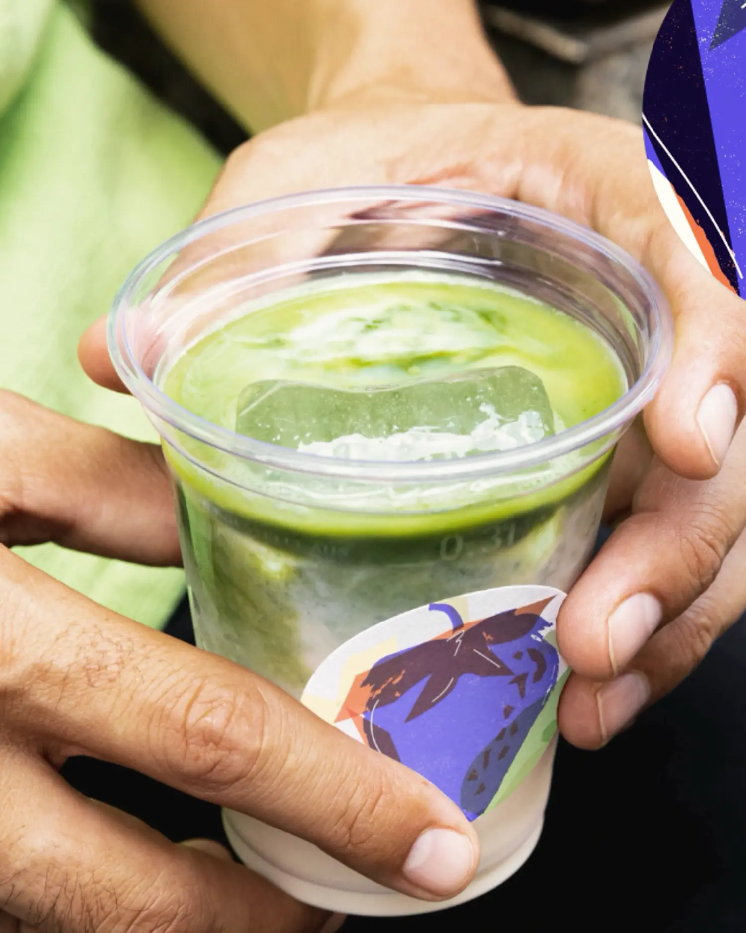 Hands sharing an iced matcha drink in a daytime social occasion