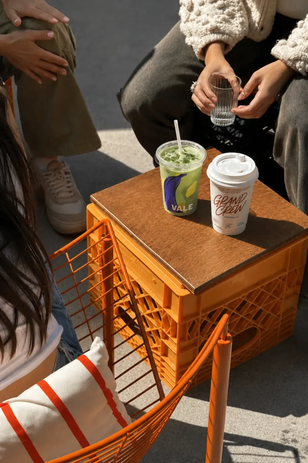 Friends sharing a matcha and a cold coffee outdoors
