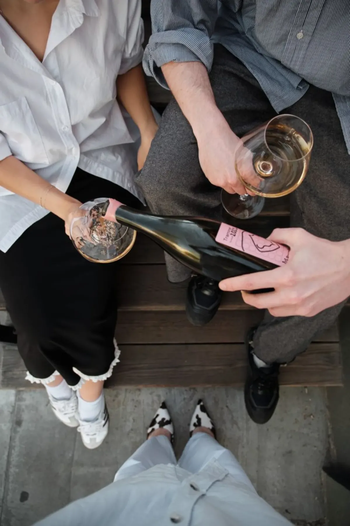 A bottle being poured for friends from an overhead view