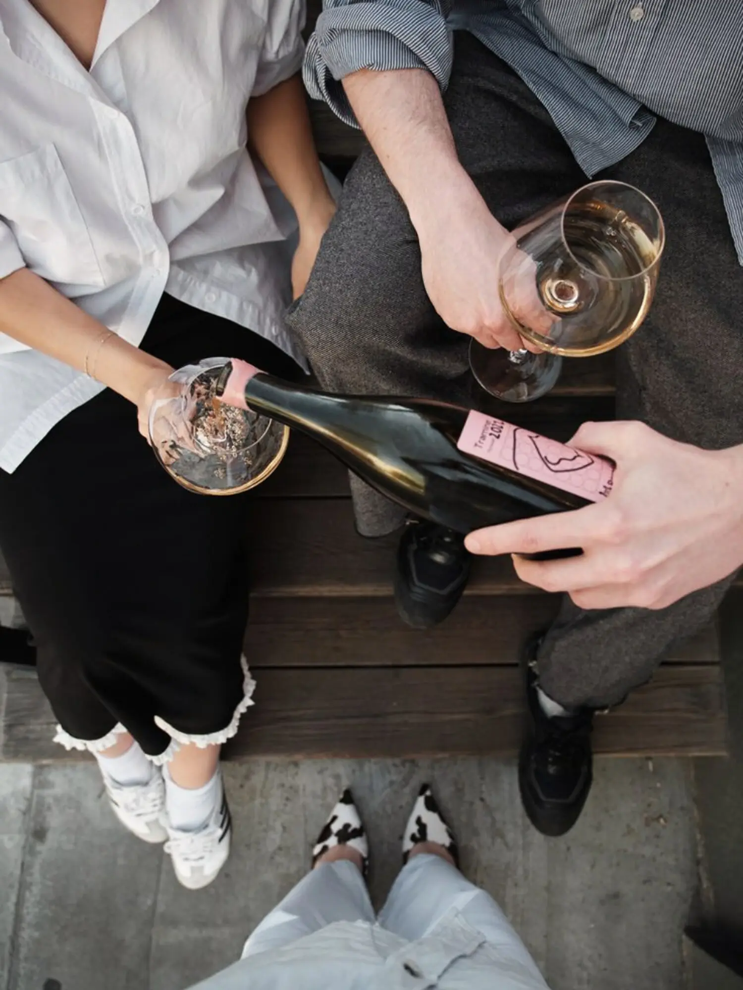 A bottle being poured for friends from an overhead view